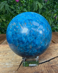 Polished Apatite sphere in vibrant ocean-blue tones patterns on a white background.