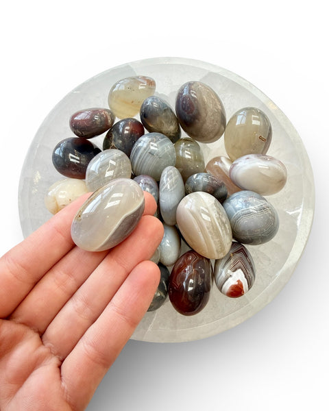Hand holding an agate tumble stone 