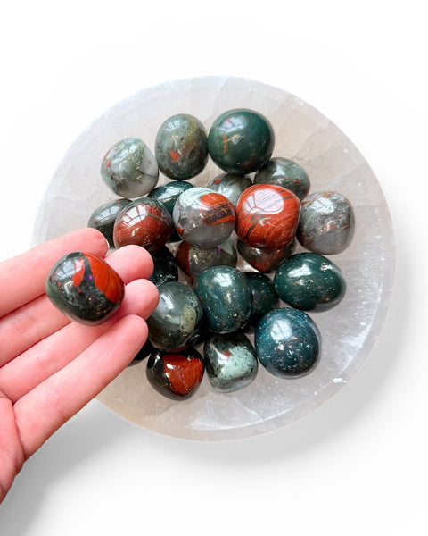 Hand holding bloodstone tumble stone