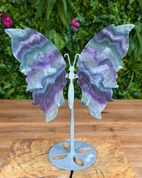 Fluorite butterfly carving on silver stand showing layered green and purple hues