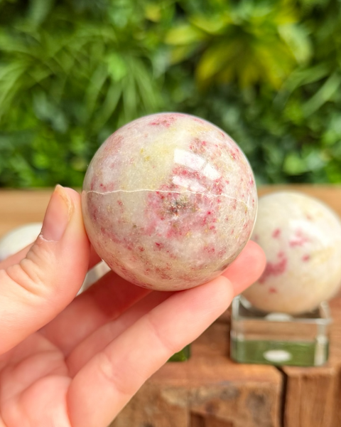 Hand holding cinnabrite sphere 