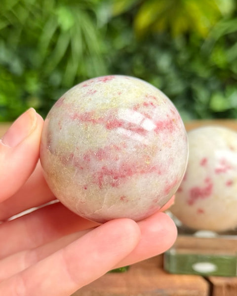 cinnabrite crystal sphere in hand