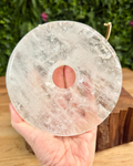 clear quartz bi disc carving held in hand