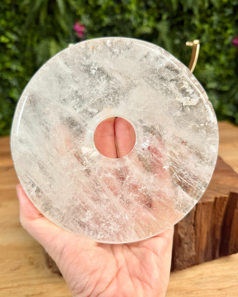 clear quartz bi disc carving held in hand