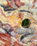 Close-up of a multicolored agate stone with a circular hole.
