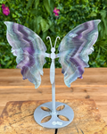 Decorative butterfly sculpture on a stand with a natural background