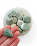 A bowl of green sardonyx tumble stones