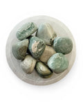 A bowl of green sardonyx tumble stones
