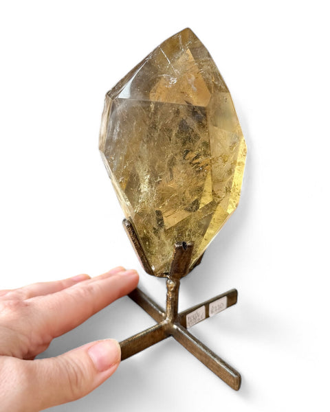 Citrine on stand with hand for scale