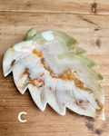 Decorative leaf-shaped object with a textured surface on a wooden background