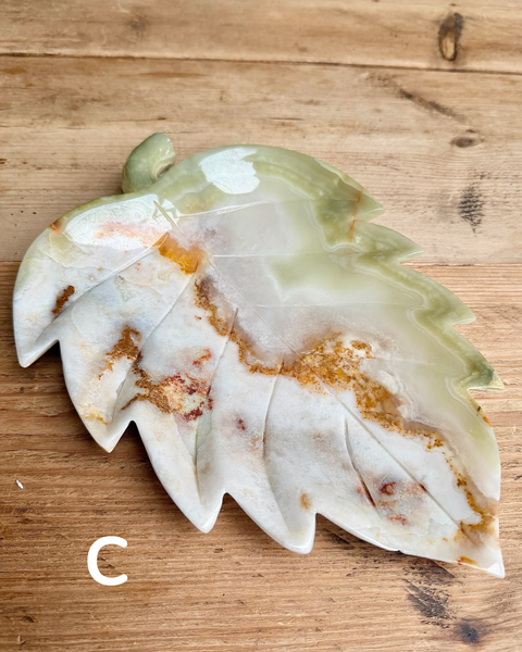 Decorative leaf-shaped object with a textured surface on a wooden background