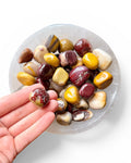Hand holding a mookaite tumble stone