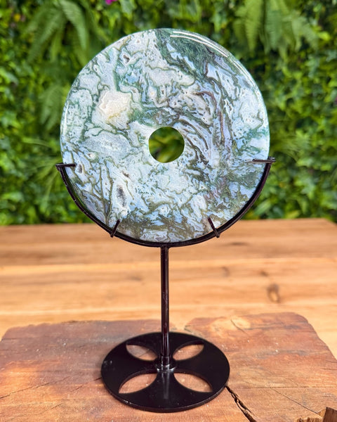 Moss agate doughnut shaped carving on stand