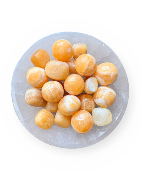 Bowl of orange calcite tumble stones
