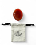 Carnelian crystal thumb worry stone with Feel Good Crystals drawstring pouch