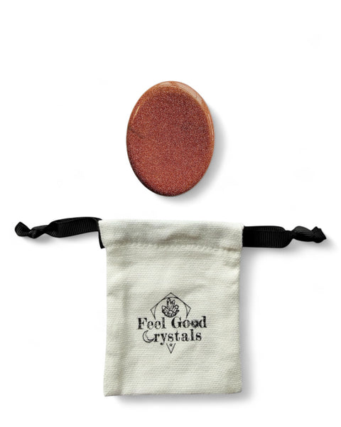 Goldstone crystal thumb worry stone with a Feel Good Crystals drawstring pouch