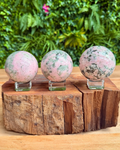 three pink and green crystal spheres a a row