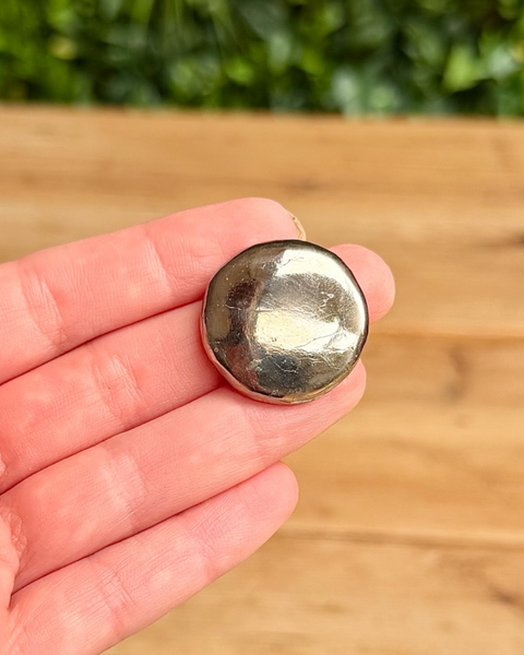 Pyrite crystal round in hand