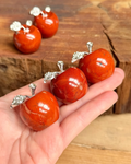 Red jasper apple carvings in a hand