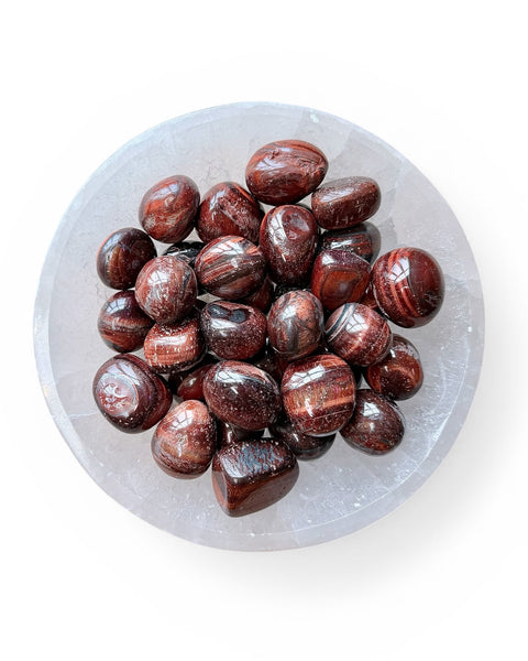 Red tiger eye stones on a clear crystal plate