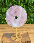 Rose quartz doughnut shaped carving on stand