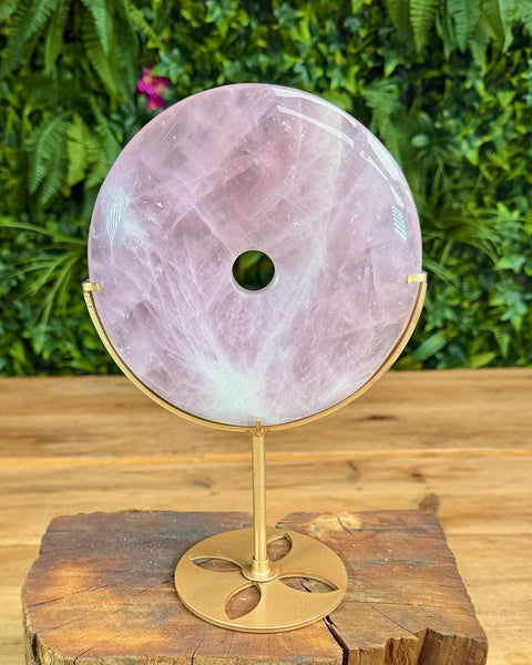 Rose quartz doughnut shaped carving on stand