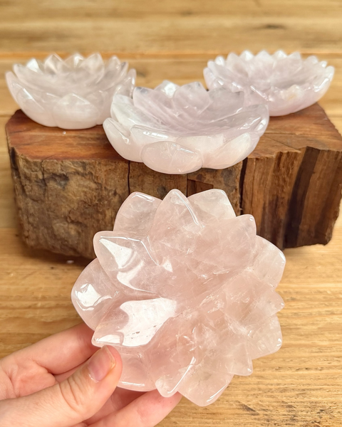 Set of crystal bowls on a wooden block with a hand holding one bowl.