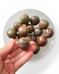 Unakite tumble stone in hand