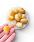 Yellow aventurine tumble stone crystal in a hand 