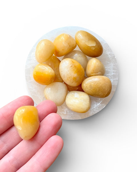 Yellow aventurine tumble stone crystal in a hand 