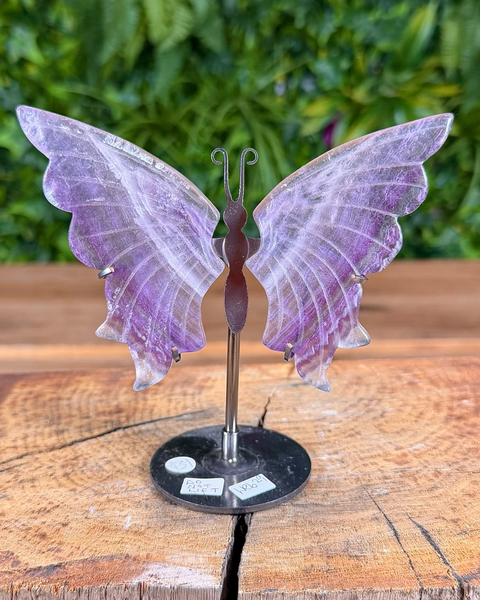 Decorative butterfly sculpture on a stand with a blurred green background