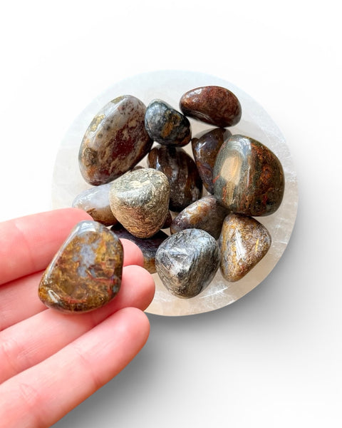Hand holding pietersite tumble stone