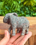 Small stone elephant figurine held in a hand with a natural background